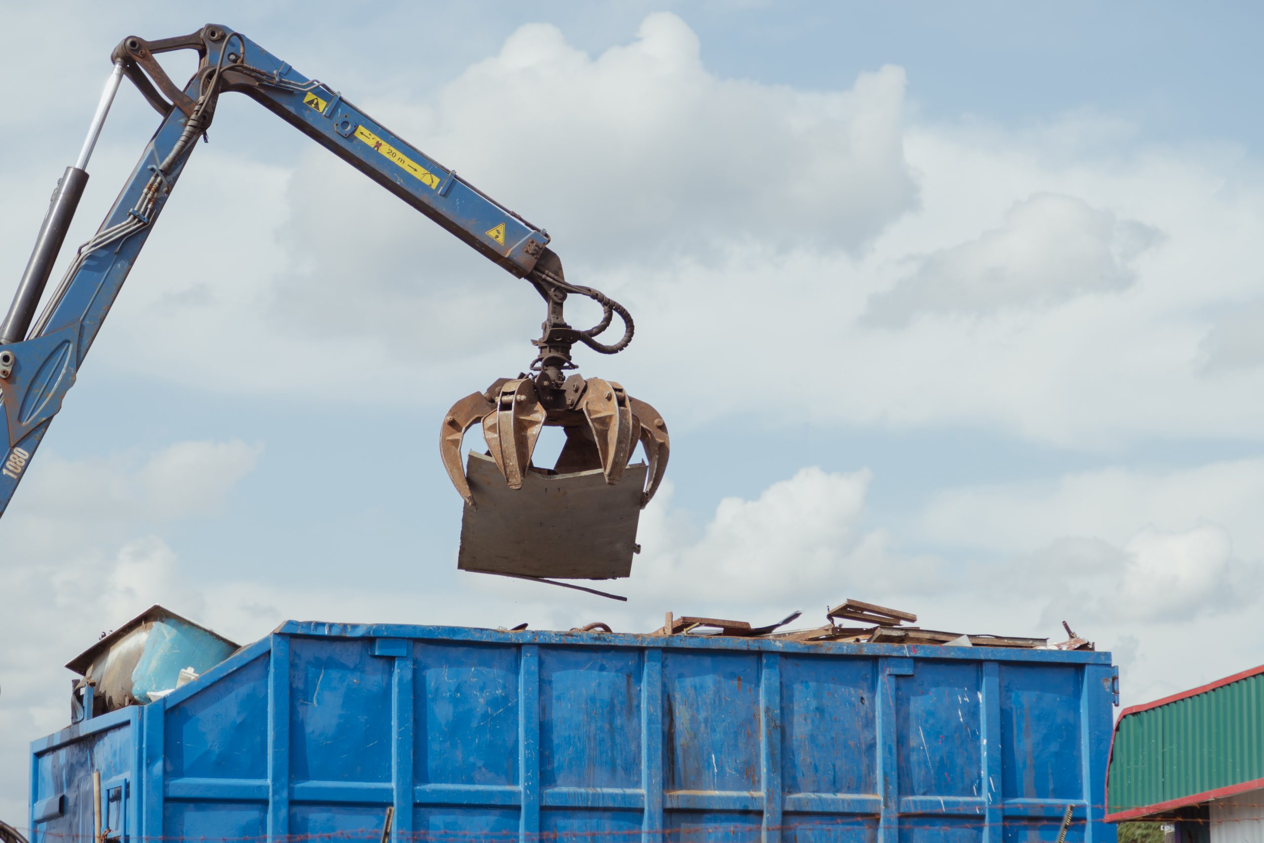 Crane-loading scrap grabber old metal at industrial metal recycling plant Crane-loading scrap grabber old metal at industrial metal recycling plant. Industrial metal waste recycling