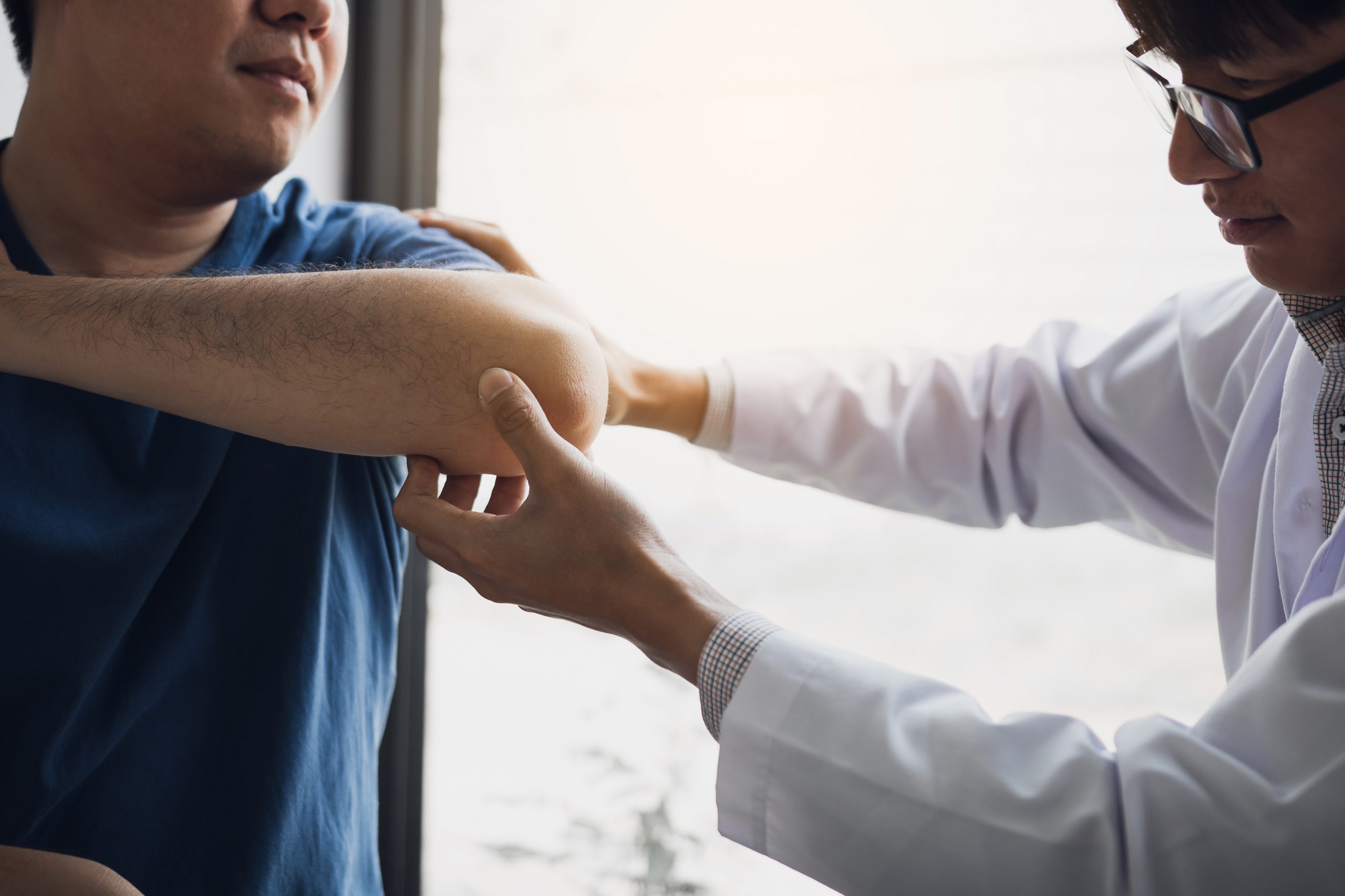 Physical therapists are checking patients elbows at the clinic o Physical therapists are checking patients elbows at the clinic office room.